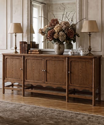 Warm wood sideboard styled with flowers and table lamps